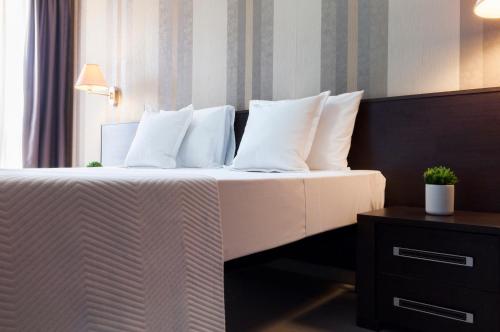 a bedroom with a bed with white sheets and pillows at Blubay Apartments by ST Hotels in Il-Gżira