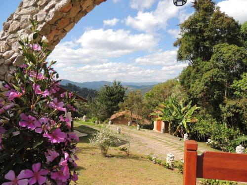 a view of a garden with purple flowers at Pousada Cantinho das Estrelas in Monte Verde