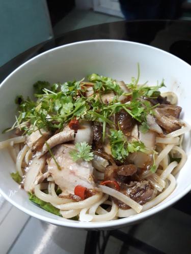 a white bowl of food with noodles and meat at Green garden house in Hoi An