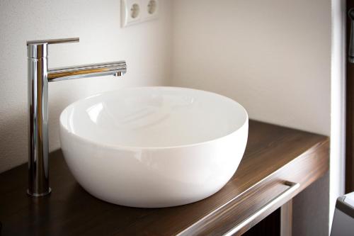 a white sink sitting on a counter in a bathroom at Pension Kleiner König in Struppen-Siedlung