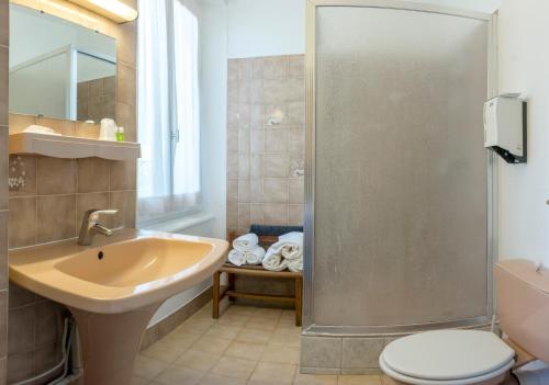 a bathroom with a sink toilet and a shower at Hôtel De Paris in Briançon