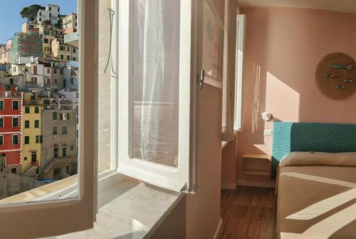 a room with a window with a view of a city at Ai Pesci Room Rental in Riomaggiore