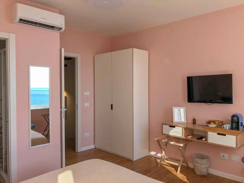 1 dormitorio con armario blanco y TV en Ai Pesci Room Rental, en Riomaggiore