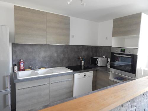 une cuisine avec un évier et un micro-ondes dans l'établissement Gîte MARY, à Mary