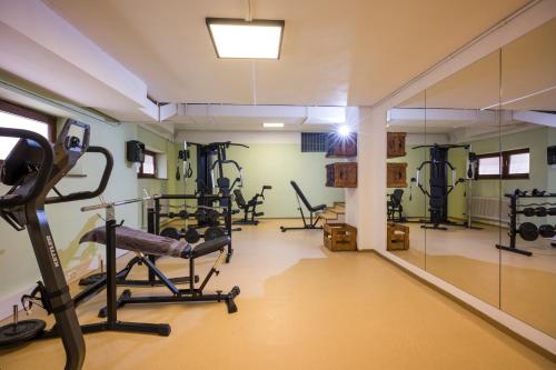 a gym with tread machines and a mirror at Sporthotel Austria in Sankt Johann in Tirol