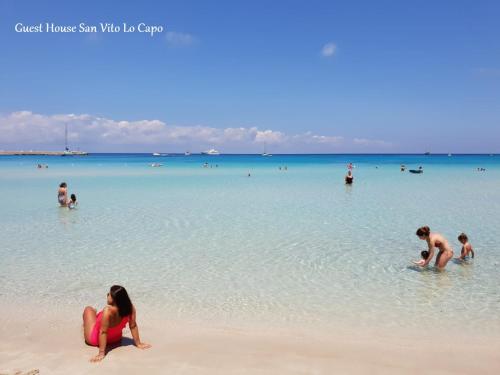 een groep mensen in het water op het strand bij Guest House San Vito Lo Capo in San Vito lo Capo