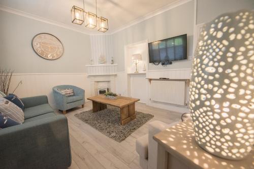 a living room with a couch and a table at Sefton Cottage in Deganwy
