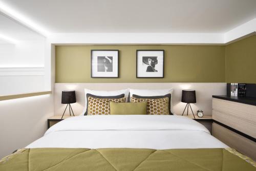 a bedroom with a large bed and two lamps at Brill Budapest Apartments in Budapest
