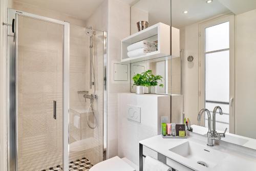 a bathroom with a shower and a sink and a toilet at Hotel Joke - Astotel in Paris