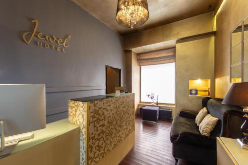 プラハにあるデザイン ホテル ジュエル プラハのロビーにソファとデスクが備わるホテルルームです。