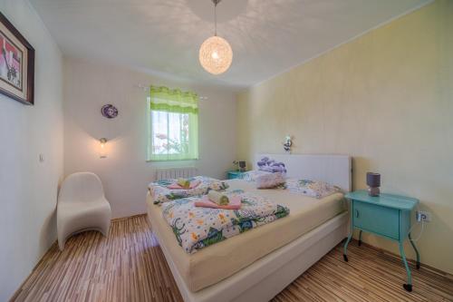 a bedroom with a bed with a blue table and a window at Apartments Melanie in Opatija