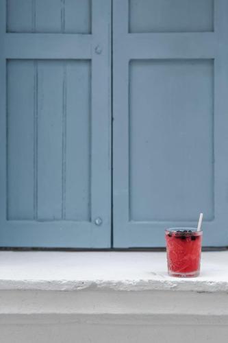 a red cup sitting on a ledge in front of a garage at Kumba Hostel in Chania Town
