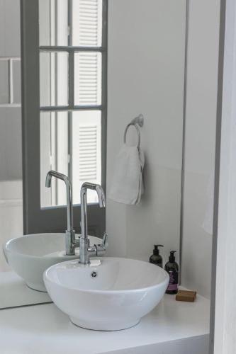 a bathroom with a white sink and a mirror at Kumba Hostel in Chania Town