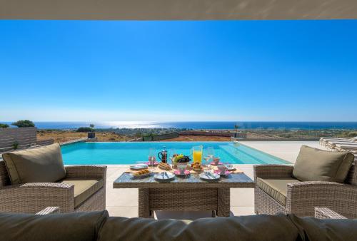 a patio with a table and chairs and a pool at Alav Pool Villa in Afantou