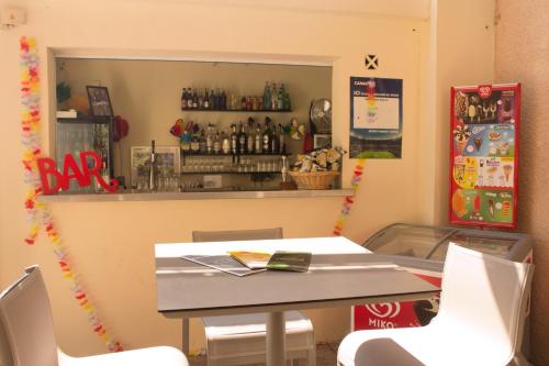 a table and chairs in a restaurant with a bar at ibis Marseille Provence Aéroport in Marignane