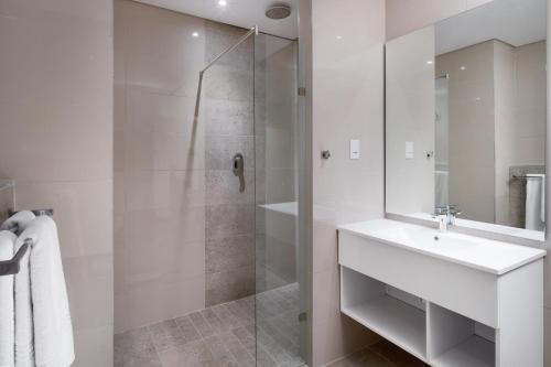 a bathroom with a shower, sink, and tub at Hotel@Hatfield in Pretoria