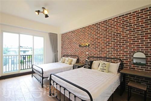 北埔鄉的住宿－茅店BnB，一间卧室设有两张床和砖墙