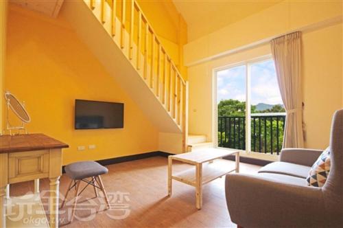 uma sala de estar amarela com um sofá e uma televisão em 茅店BnB em Beipu