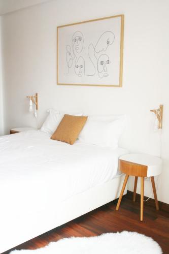 a white bedroom with a white bed and a table at Gare Do Sol Free Parking and Smart TV in Aveiro