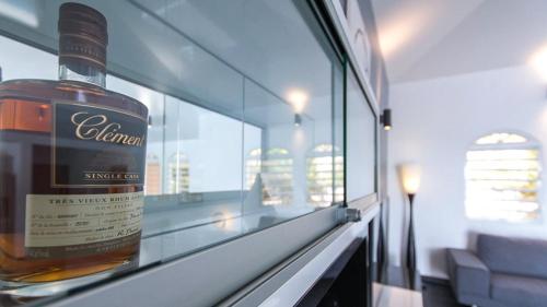 a bottle of whisky sitting on a shelf in a room at Villa La Ressource in Le François
