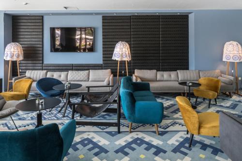 a lobby with couches and tables and chairs at Falkensteiner Club Funimation Borik in Zadar