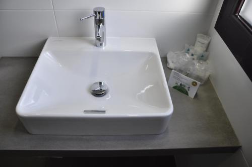 a white sink sitting on a counter in a bathroom at Hotel & Spa Real Jaca in Jaca