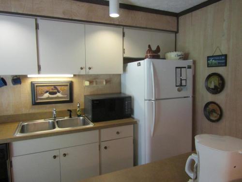 La cuisine est équipée d'un évier et d'un réfrigérateur blanc. dans l'établissement The Glen II Unit 59 Condo, à Sugar Mountain