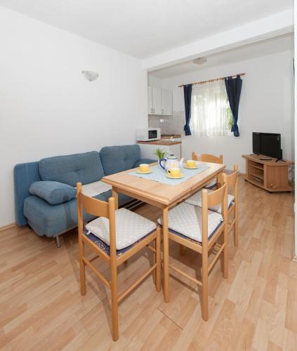 a living room with a table and a blue couch at Apartments IVO in Tučepi