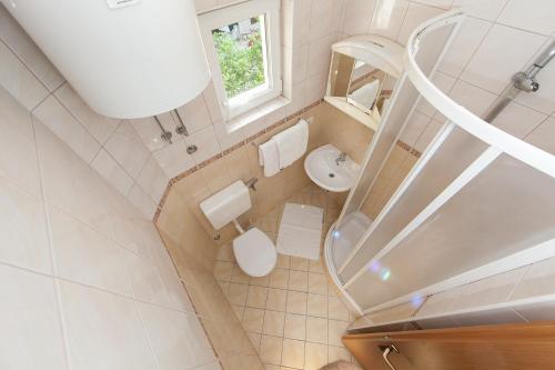 a small bathroom with a toilet and a sink at Apartments IVO in Tučepi