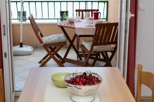 a bowl of cherries sitting on a table in a kitchen at Apartments IVO in Tučepi
