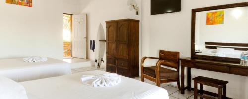 a bedroom with two beds and a desk and a mirror at Bungalows Zicatela in Puerto Escondido