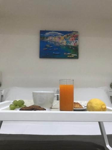 een dienblad met een glas sinaasappelsap op een tafel bij Virgilio’s Garden in Castellammare di Stabia
