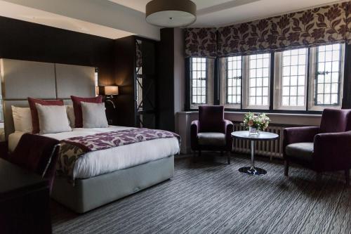 a hotel room with a bed and a table and chairs at Abbey House Hotel in Barrow in Furness