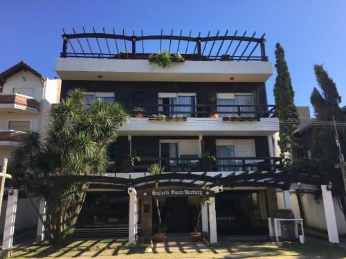 Un gran edificio blanco con un cartel delante. en Hostería Santa Bárbara, en Villa Gesell