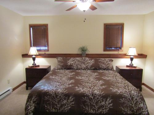 een slaapkamer met een bed met 2 nachtkastjes en 2 lampen bij The Crest 200-J Condo in Sugar Mountain