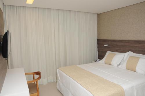 a hotel room with a bed and a television at Reserve Hotel in Surubim