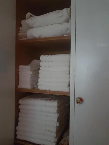 a shelf filled with white towels in a bathroom at Marco's house in Dolianova