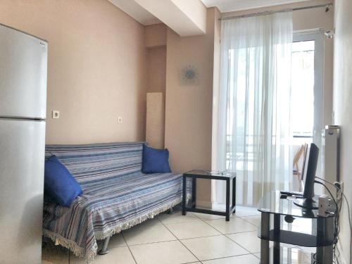 a room with a couch with blue pillows and a window at Pireaus Port Cosy apartment Wifi AC in Piraeus