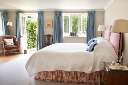 a bedroom with a large bed with blue curtains at Gutchpool Farm in Gillingham