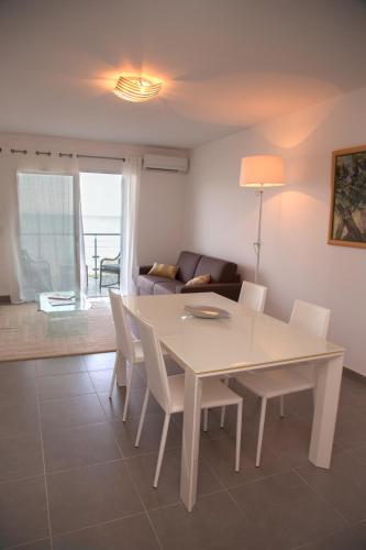 une salle à manger avec une table et des chaises blanches dans l'établissement Résidence Villa Tyrrenia, à Macinaggio