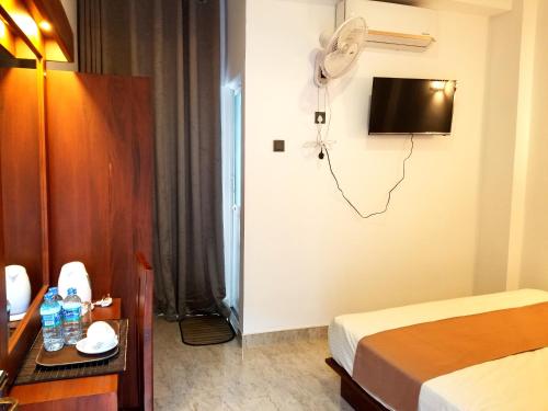 a hotel room with a bed and a table and a television at Queens mount in Kandy