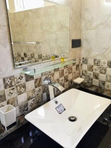 a bathroom with a white sink and a mirror at Queens mount in Kandy