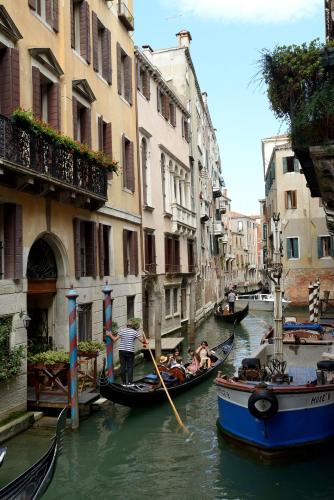a group of people riding in gondolas down a canal at Residence La Fenice in Venice