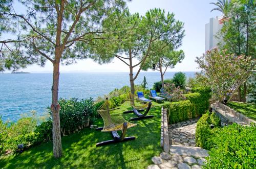 un jardín con vistas al océano en Korumar Hotel Deluxe, en Kusadasi