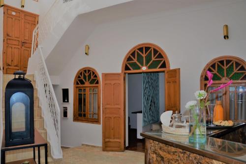 una sala de estar con puertas de madera y una escalera en Dar Korsan en Rabat