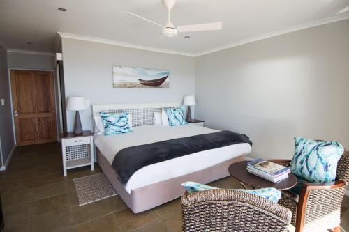 Schlafzimmer mit einem Bett, einem Tisch und Stühlen in der Unterkunft Oystercatcher Villa in St Helena Bay