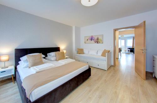 a large bedroom with a large bed and a couch at City Center apartments in Mostar