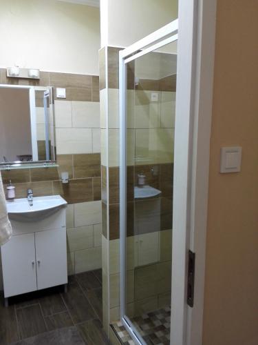 a bathroom with a glass shower and a sink at Kerékvár apartman Gyula in Gyula