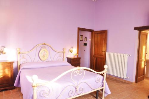 a white bed in a bedroom with purple walls at Agriturismo Arcobaleno della Torretta in Giano dellʼUmbria