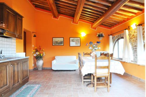 a kitchen and dining room with an orange wall at Agriturismo Arcobaleno della Torretta in Giano dellʼUmbria